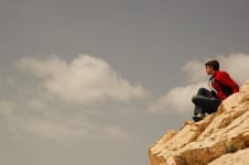Turista no alto de uma pedra