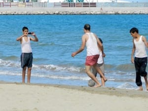 Crianças jogando bola na praia de Tânger, Marrocos