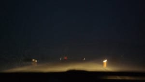 Estrada islandesa com pouca visibilidade, antes do sol nascer e com rajadas de vento e neve