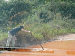 Testando a profundidade da grande poça d'água que ocupava alguns metros de estrada próximo à Bonito, Mato Grosso do Sul