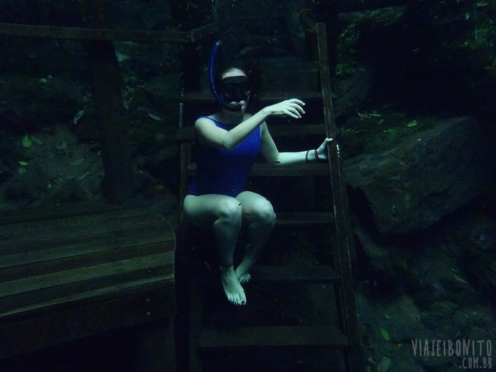 Gisele sentando na escada submersa do deck, em Lagoa Misteriosa, Bonito, Mato Grosso do Sul