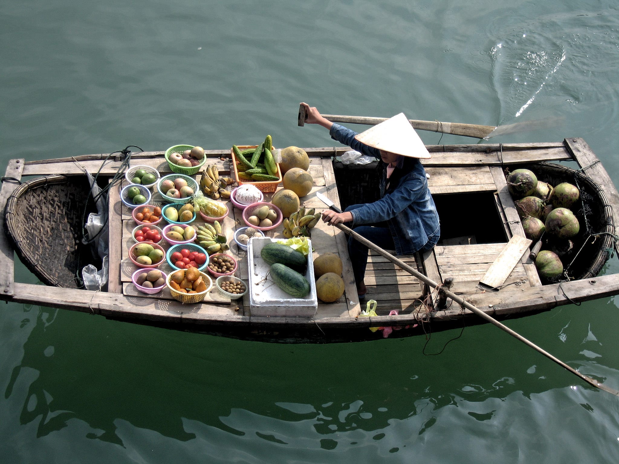 Barco cheio de frutas na Baía de Ha Long, Vietnã