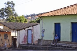 Homem sentado na porta de casa, passando o tempo, em Joaquim Murtinho, Minas Gerais