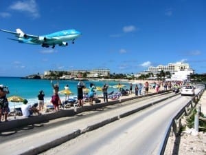 Avião pousando no aeroporto de Saint Martin, próximo aos turistas