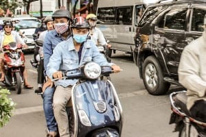 Motociclistas em Ho Chi Minh, Vietnã, usando máscaras cirúrgicas