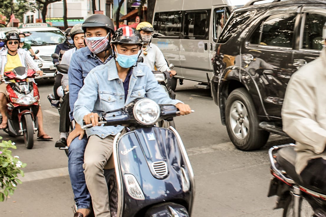 Motociclistas em Ho Chi Minh, Vietnã, usando máscaras cirúrgicas