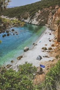 Campistas aproveitam a praia de Halikiada, na ilha de Agistri, Grécia