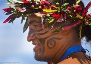 Homem usando um arranjo feito com plantas e o rosto pintado para o Festival de Tapati, na Ilha de Páscoa