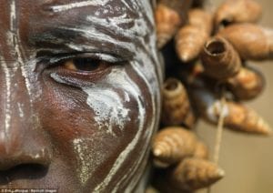 Mulher da tribo Mursi com o rosto pintado e um cocar de conchas. No Vale de Omo, Etiópia