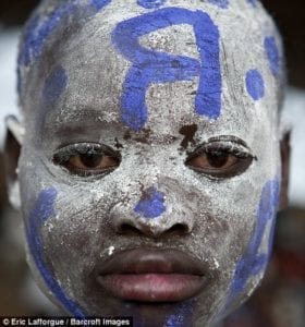 Um menino fanático por futebol assiste a uma partida em Ruanda