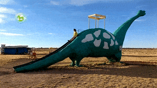 Gisele escorregando nas costas de um dinossauro, como Fred fazia na abertura do desenho animado