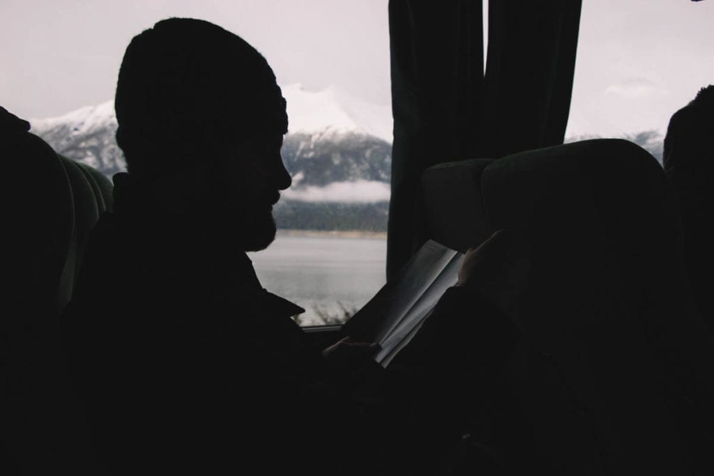 Adriano lendo durante uma viagem de ônibus