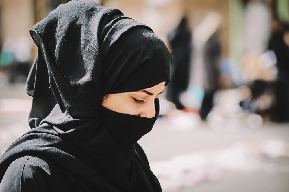 Mulher muçulmana com túnica preta (abaia) e lenço (hijab)