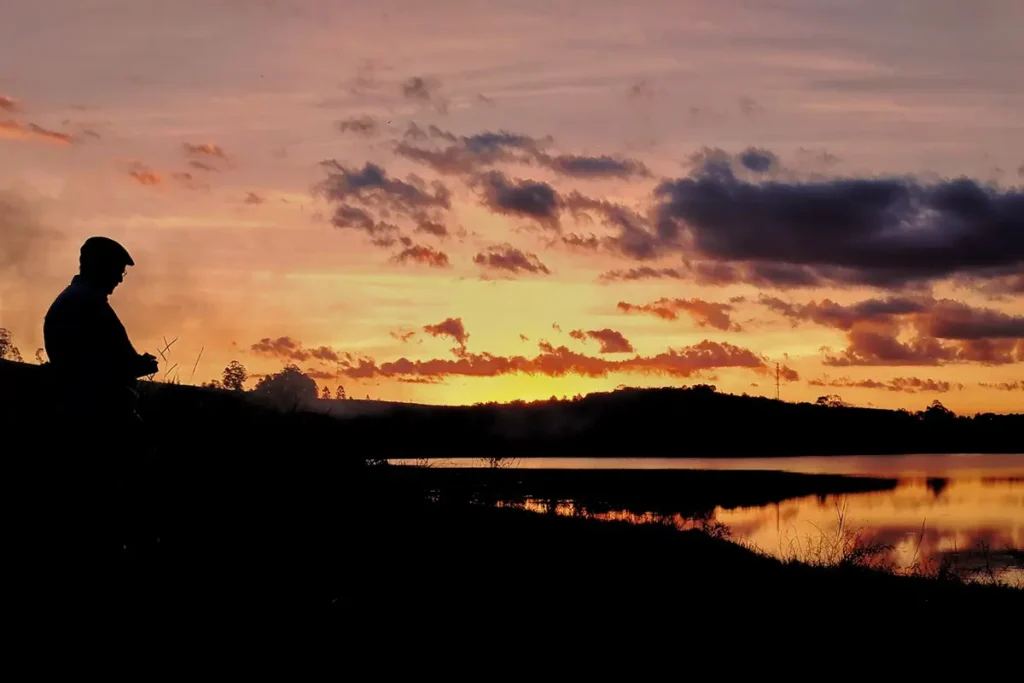 Silhueta de homem durante o pôr do sol na Represa São Pedro, em Juiz de Fora